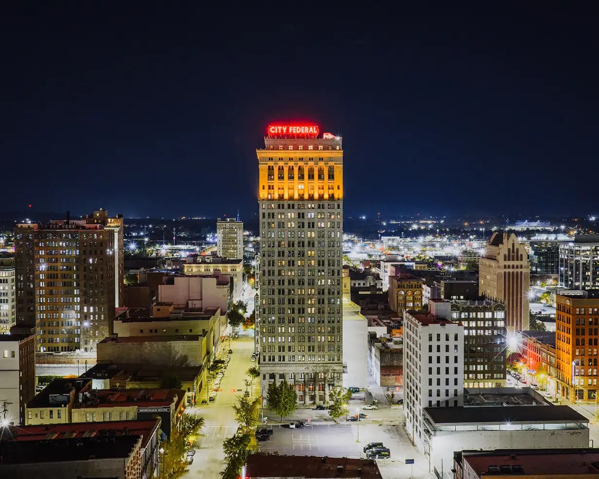 City Federal Building and downtown Birmingham, Alabama skyline at night, a charter bus pickup area