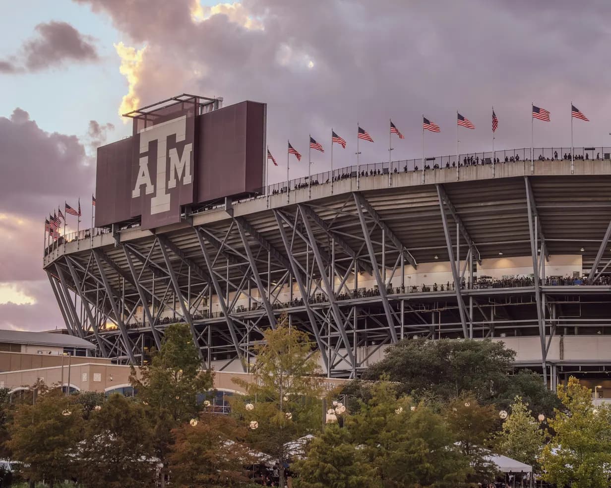 Kyle Field at Texas A&M University in College Station, Texas, with the Aggie logo and American flags at sunset