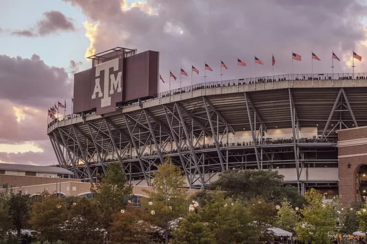Kyle Field at Texas A&M University in College Station, Texas, with the Aggie logo and American flags at sunset