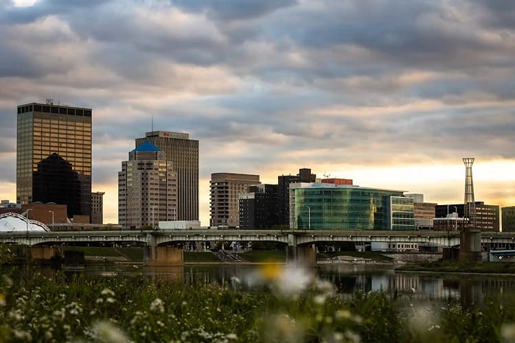 Wildflowers along the Great Miami River at sunset with the Dayton, Ohio skyline, a pickup area for charter bus groups