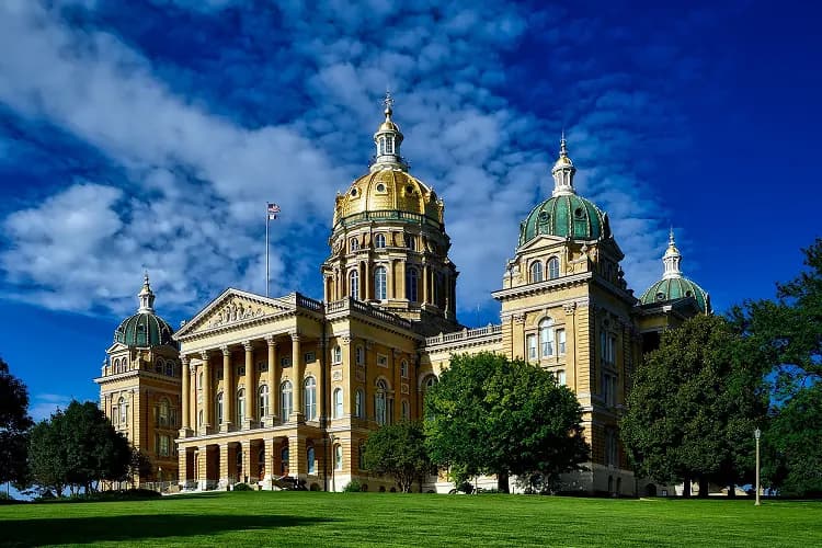 Gold dome of the Iowa State Capitol above a green lawn in Des Moines, Iowa, a charter bus lobby-day stop