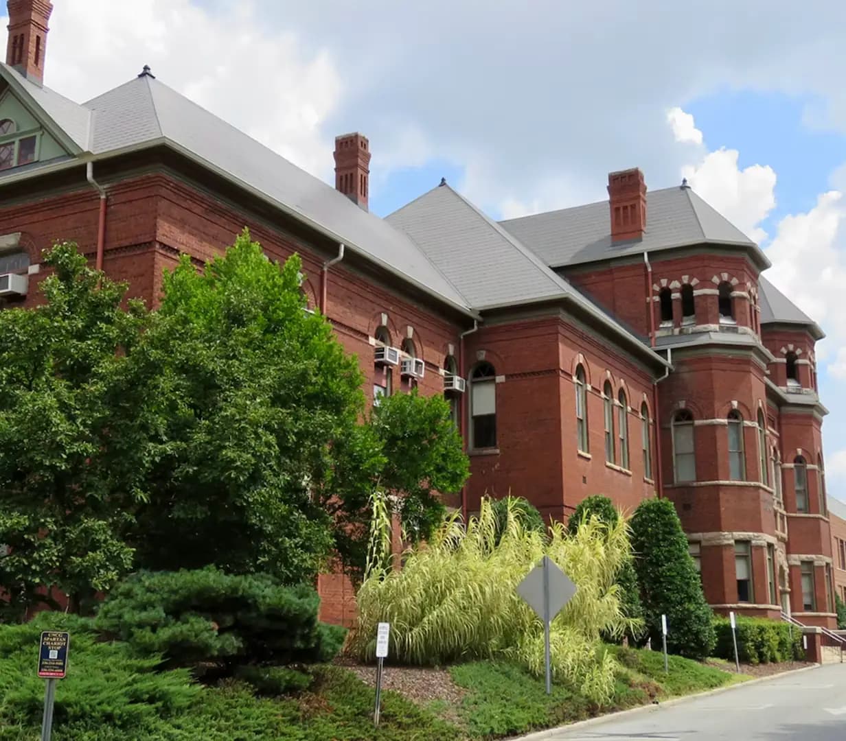Historic Victorian brick building with turrets in downtown Greensboro, North Carolina, on the streets charter bus operators navigate near the Tanger Center