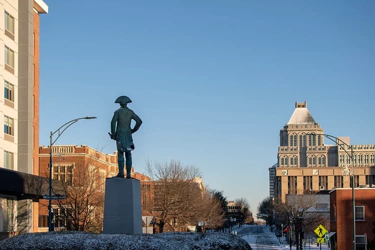 Revolutionary War statue in downtown Greensboro, North Carolina in winter, near the Art Deco buildings where charter bus groups stage hotel pickups