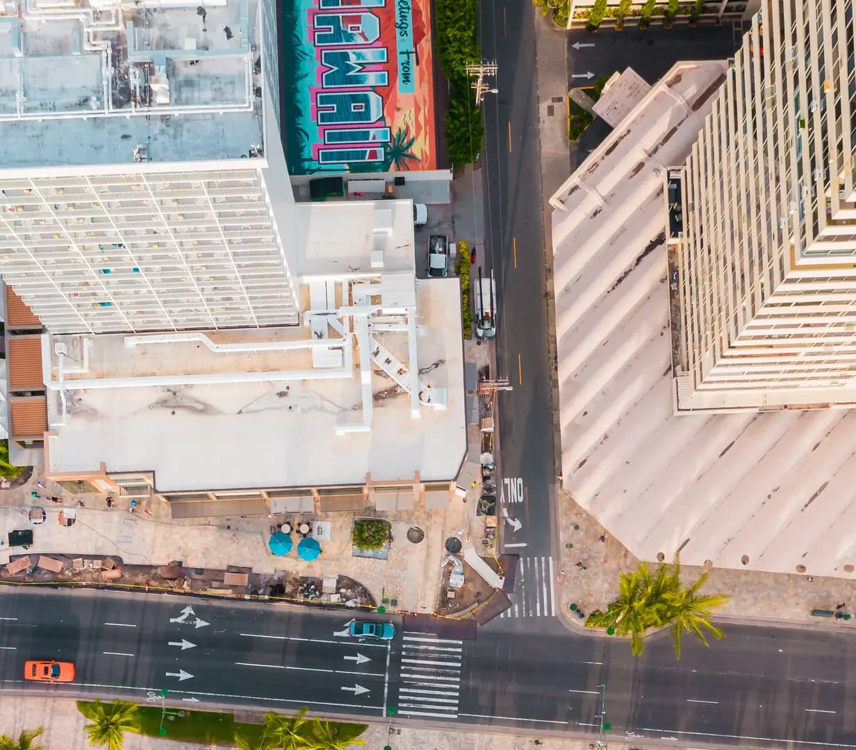Overhead view of Waikiki hotels, a Greetings from Hawaii mural and Kalakaua Avenue beside the beach in Honolulu, Hawaii