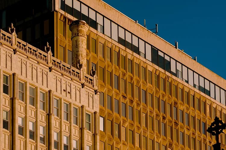Golden hour light on downtown Jackson, Mississippi building facades, a charter bus Capitol-complex pickup point