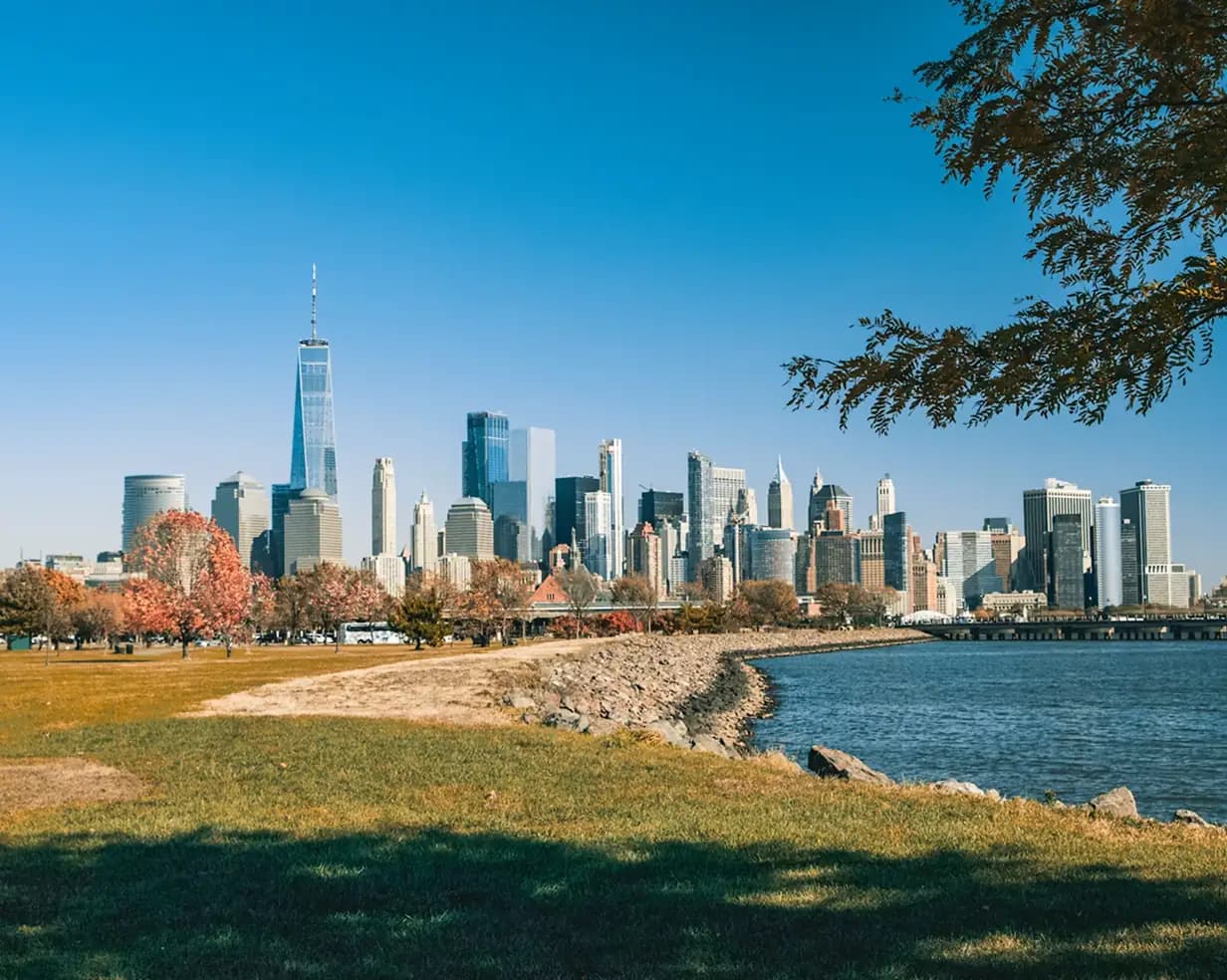 Manhattan skyline across the Hudson from Liberty State Park in Jersey City, New Jersey, in autumn, a wedding-venue and CRRNJ Terminal pickup area for charter bus groups