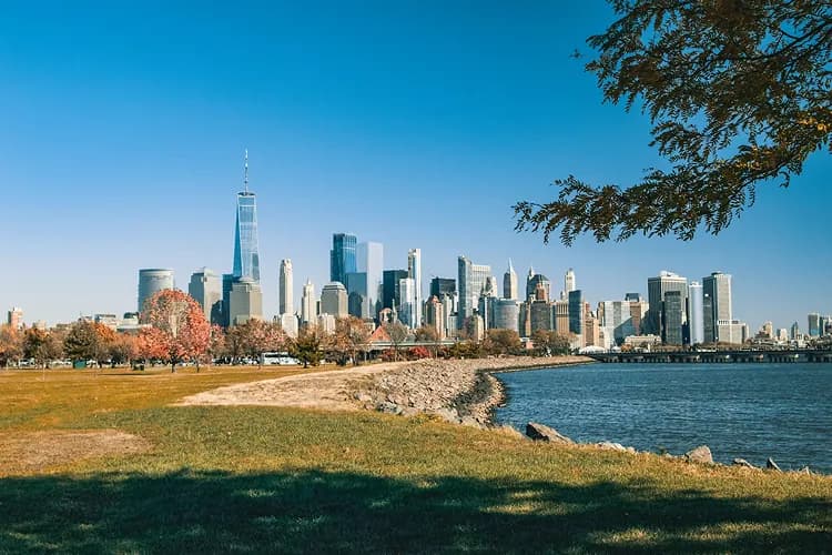 Manhattan skyline across the Hudson from Liberty State Park in Jersey City, New Jersey, in autumn, a wedding-venue and CRRNJ Terminal pickup area for charter bus groups