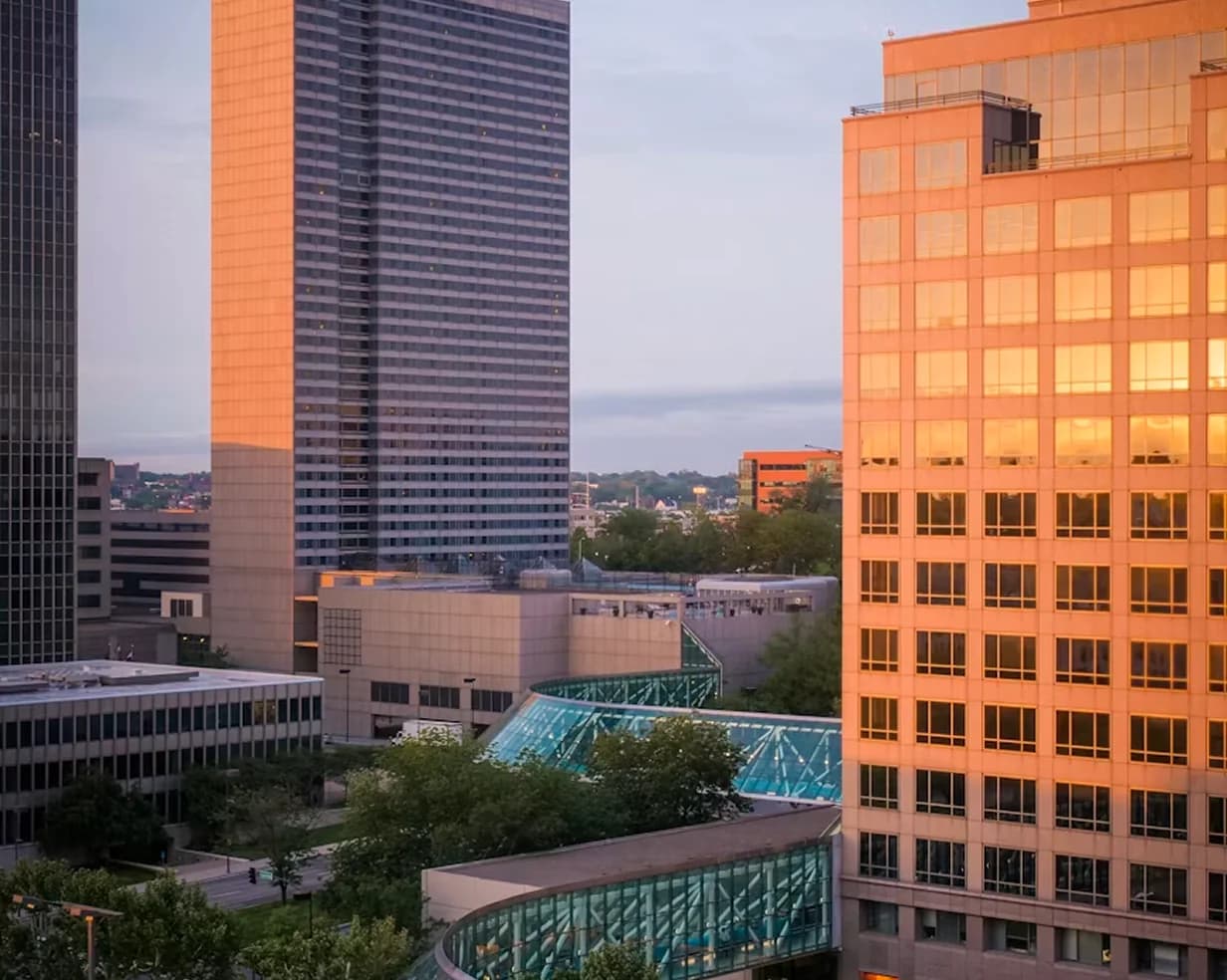 Downtown Kansas City skyline glass towers at golden hour, a charter bus pickup area