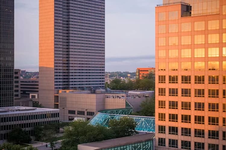 Downtown Kansas City skyline glass towers at golden hour, a charter bus pickup area