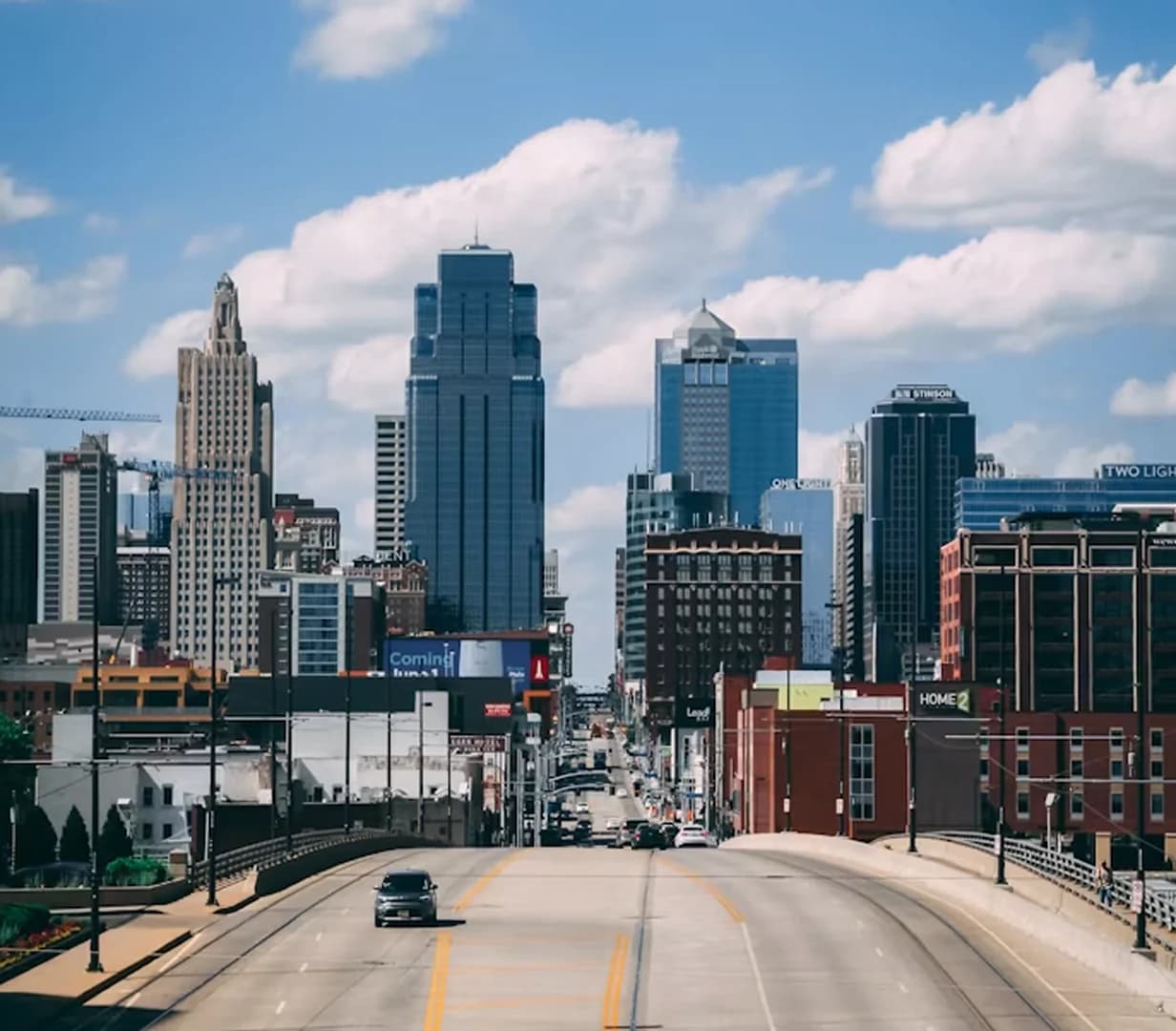 Kansas City skyline and skyscrapers from the highway under clouds, a charter bus travel route