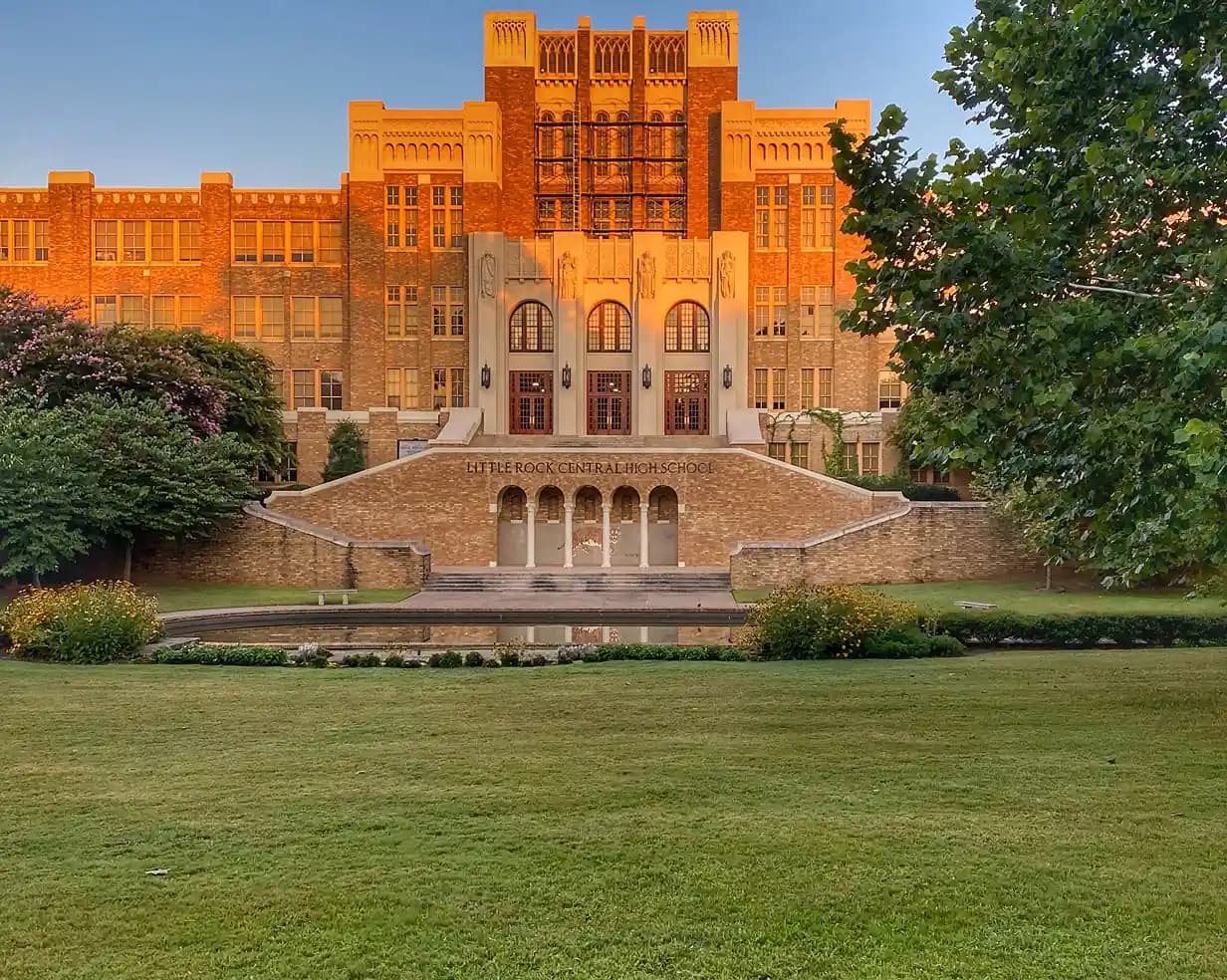 Historic facade of Little Rock Central High School at golden hour, a charter bus field-trip destination
