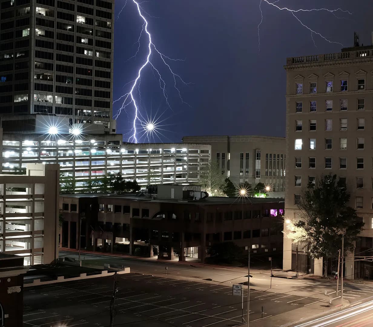 Lightning storm over downtown Little Rock, Arkansas buildings at night, a charter bus pickup area