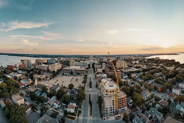 Wisconsin State Capitol dome aerial over the Madison, Wisconsin isthmus at sunset, a charter bus lobby-day stop