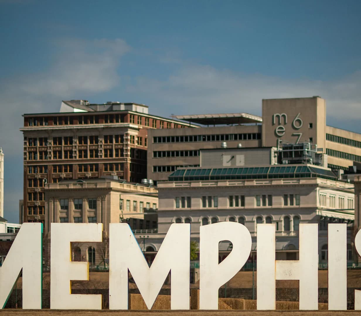 Downtown Memphis, Tennessee sign letters against the skyline, a charter bus hotel pickup area