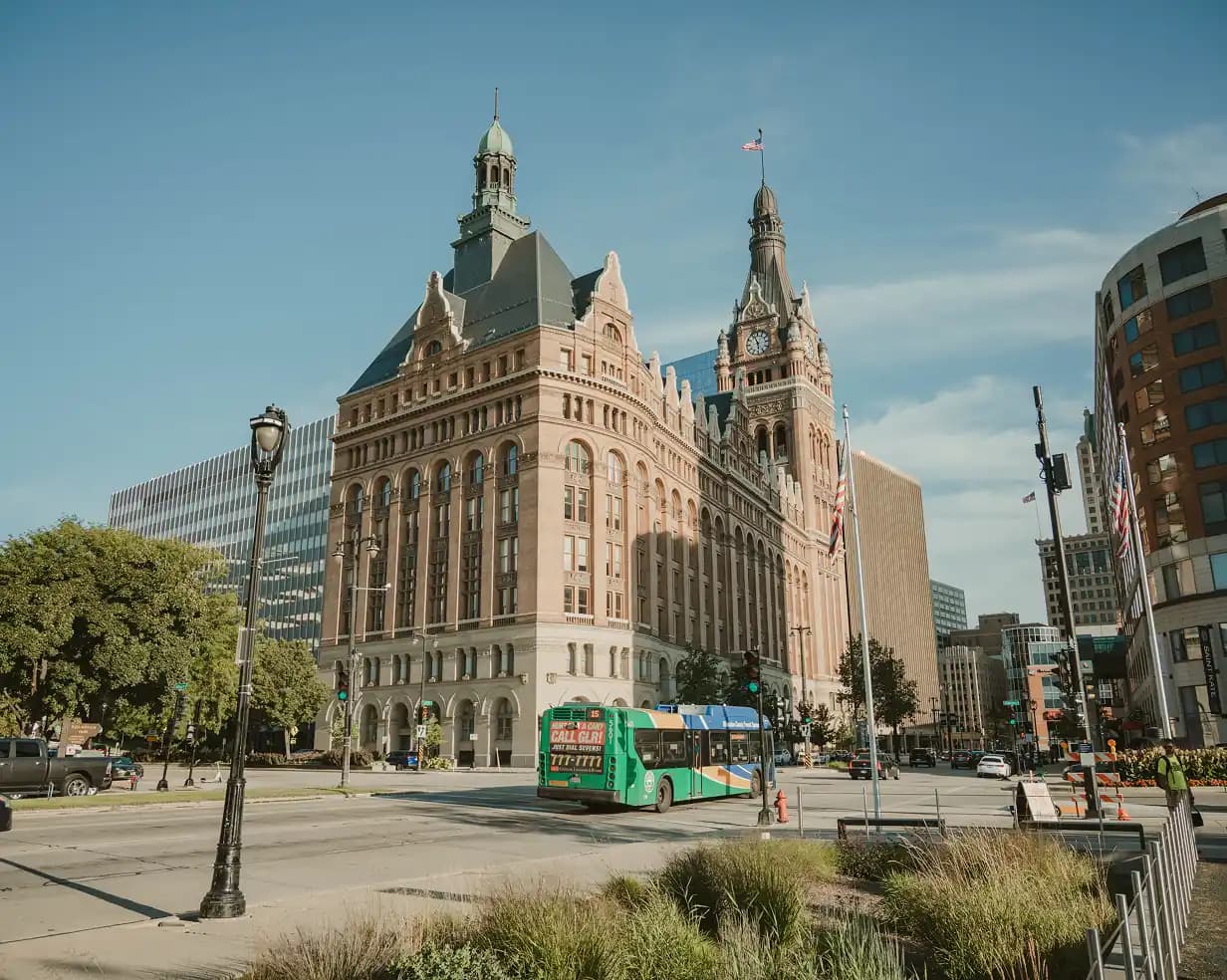 Milwaukee, Wisconsin City Hall clock tower with a charter bus on the downtown street below, a common pickup area for group tours