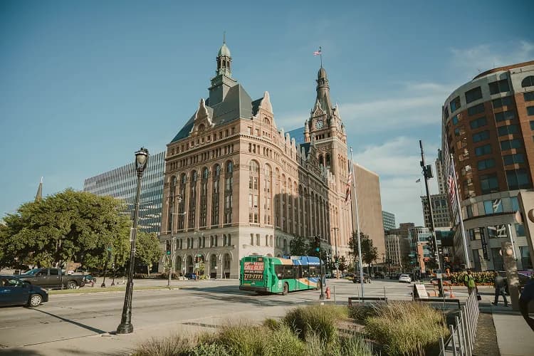 Milwaukee, Wisconsin City Hall clock tower with a charter bus on the downtown street below, a common pickup area for group tours