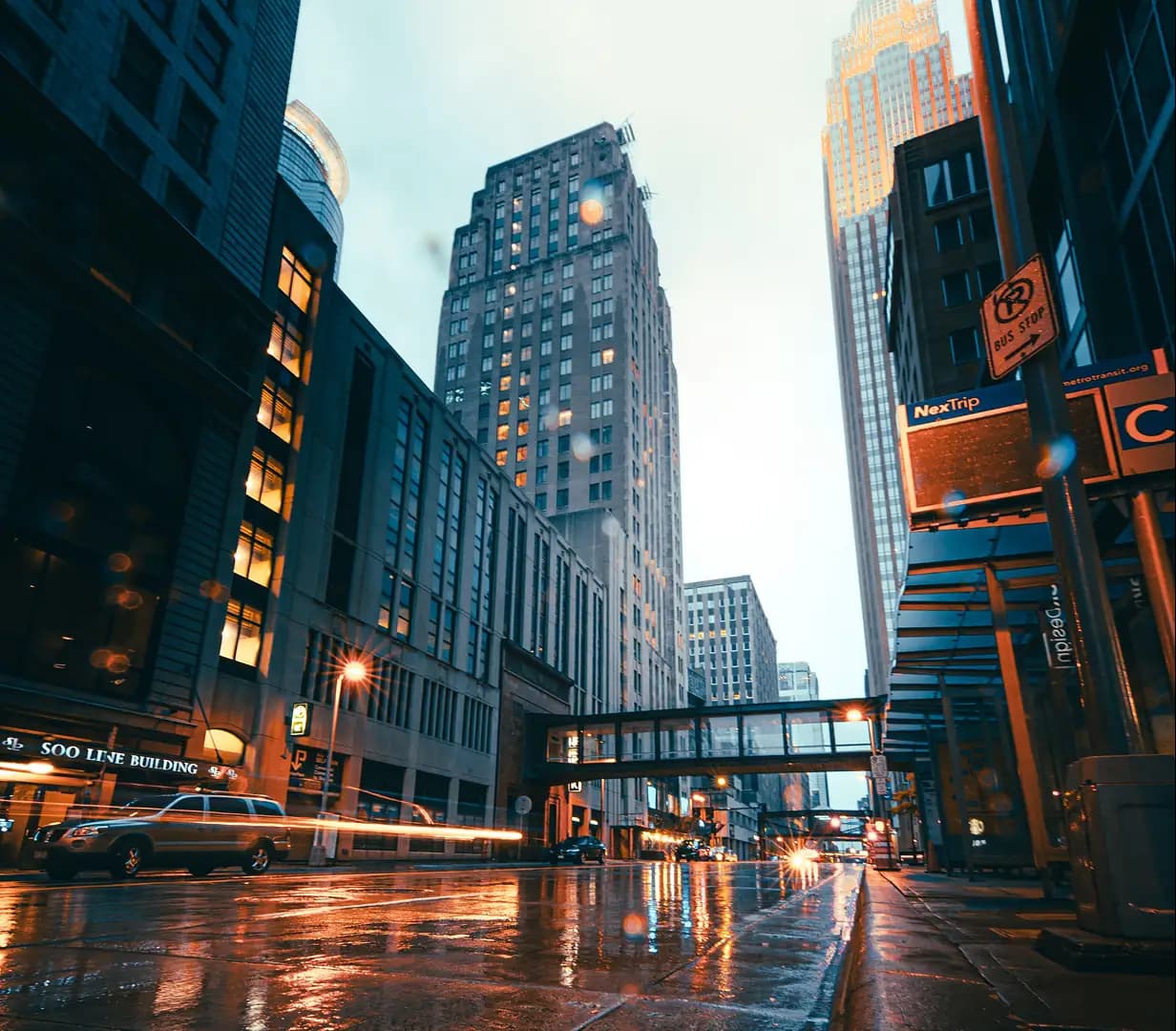 Rain-slicked downtown Minneapolis street at dusk beside the historic Soo Line Building
