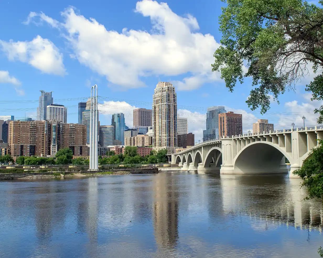 The Minneapolis skyline behind the arched Third Avenue Bridge over the Mississippi River