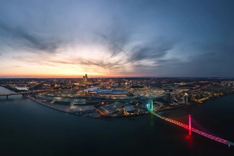 Aerial view of the Omaha, Nebraska skyline at sunset, with the lit Bob Kerrey Pedestrian Bridge over the Missouri River