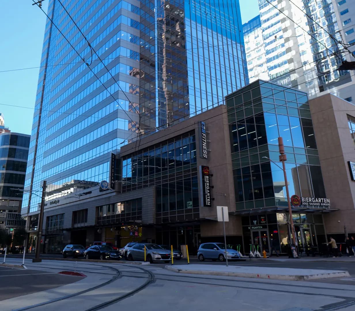Glass office tower at CityScape above Valley Metro light rail tracks and overhead wires in downtown Phoenix, Arizona