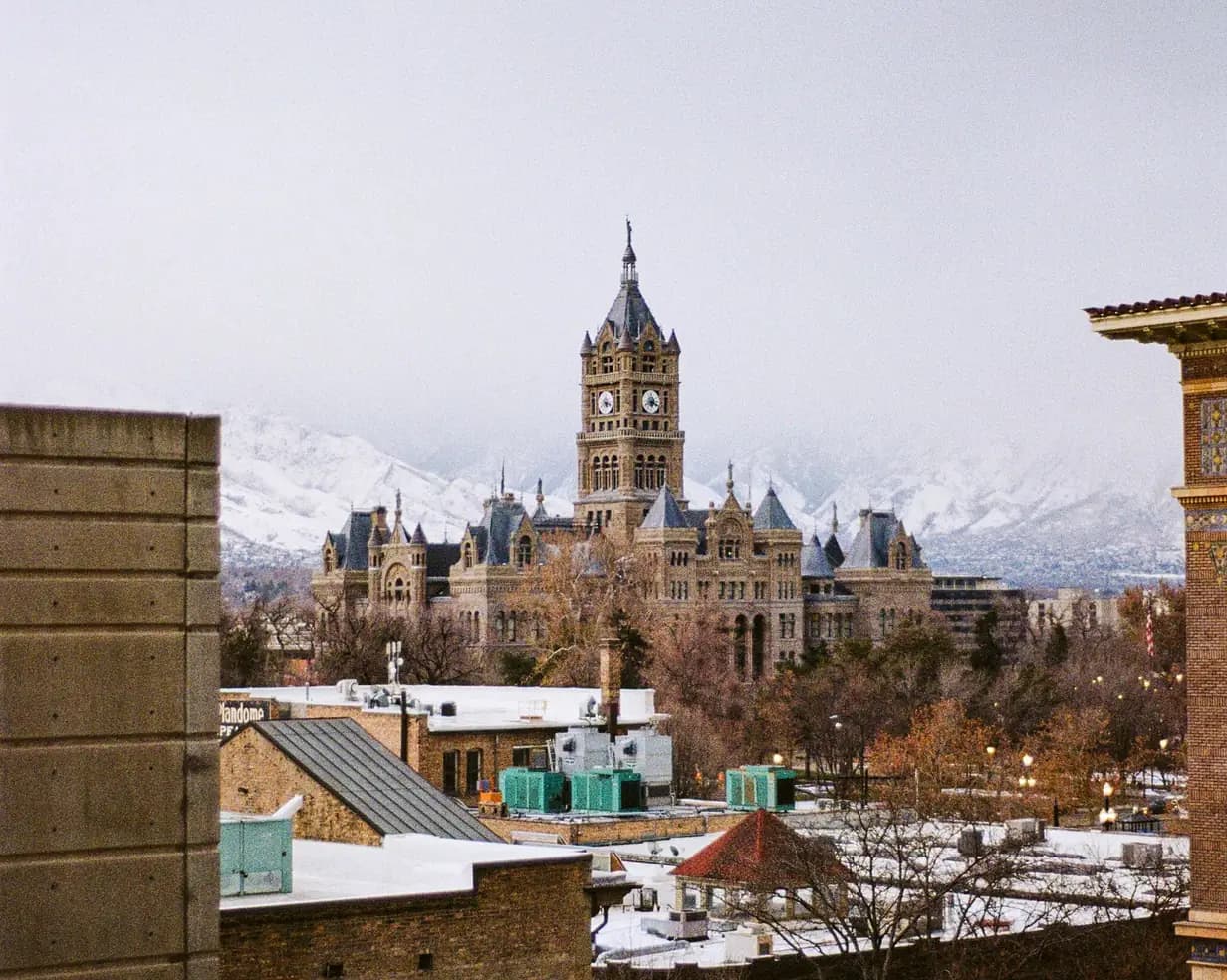 Salt Lake City and County Building clock tower with the snow-capped Wasatch Mountains behind, in Salt Lake City, Utah