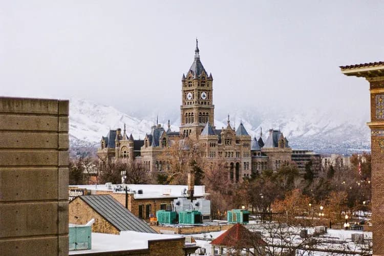 Salt Lake City and County Building clock tower with the snow-capped Wasatch Mountains behind, in Salt Lake City, Utah