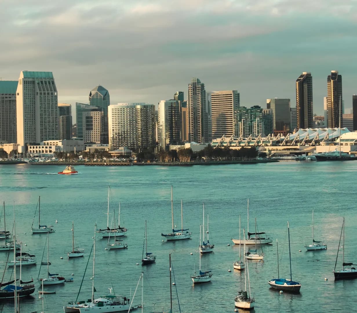 Sailboats moored on San Diego Bay with the downtown San Diego, California skyline and convention center behind