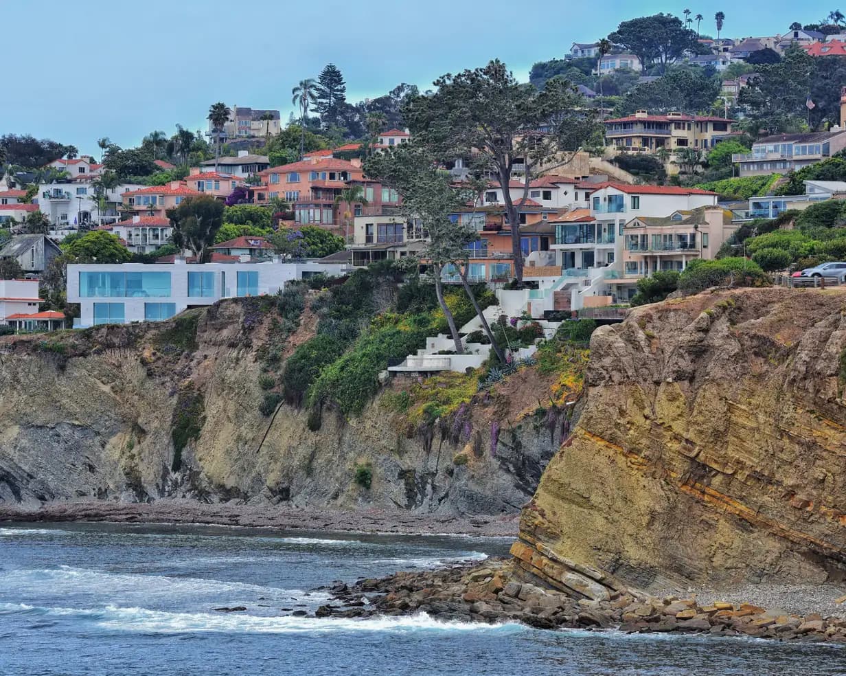 Cliffside homes and palm trees above the rocky shoreline and ocean in La Jolla, San Diego, California