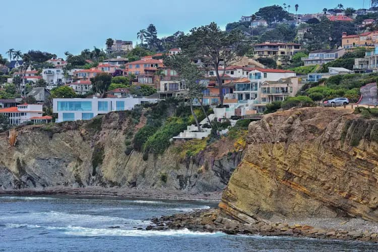 Cliffside homes and palm trees above the rocky shoreline and ocean in La Jolla, San Diego, California