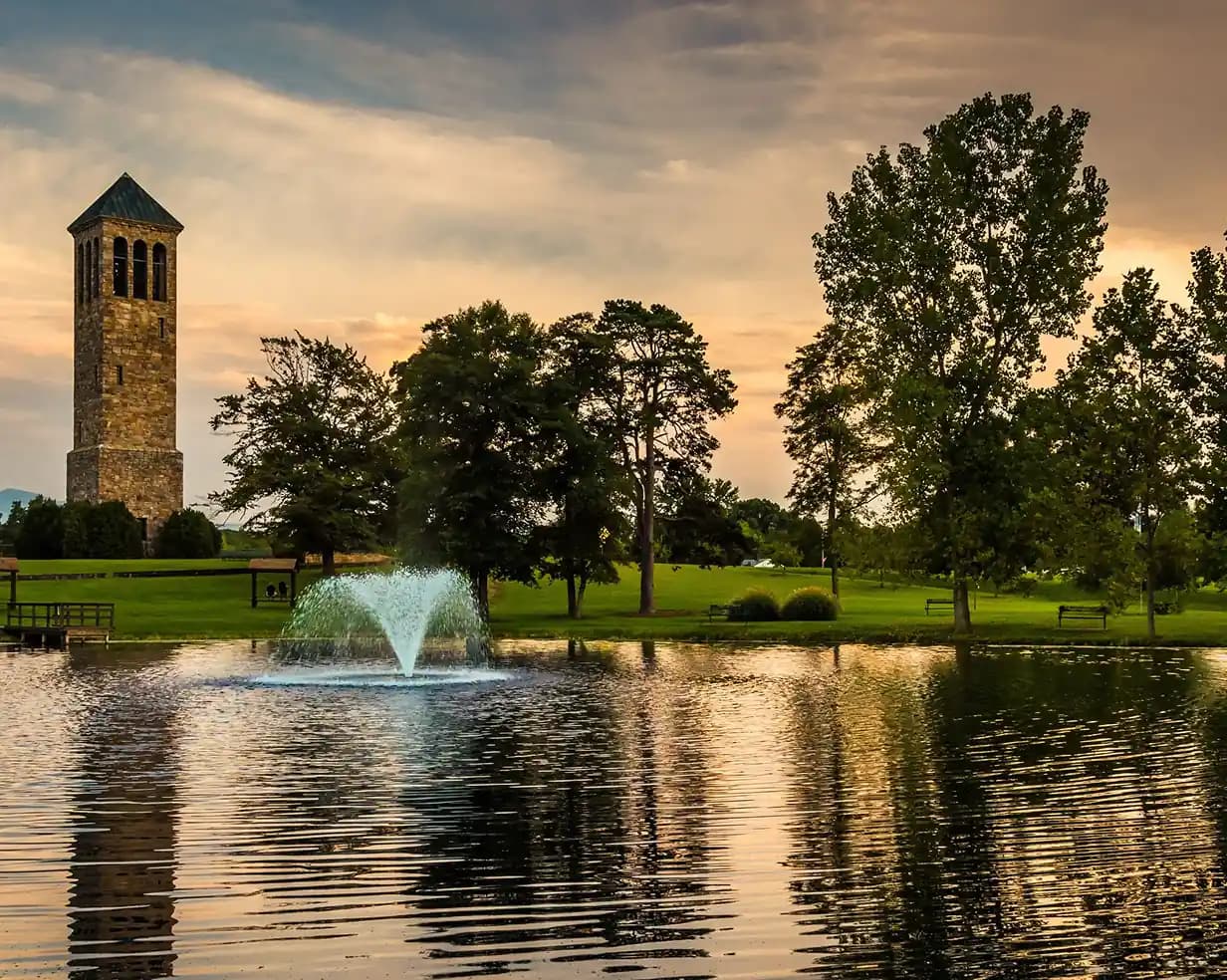 Stone bell tower and fountain pond at sunset in Springfield, Virginia, where charter bus groups stage for DC day trips