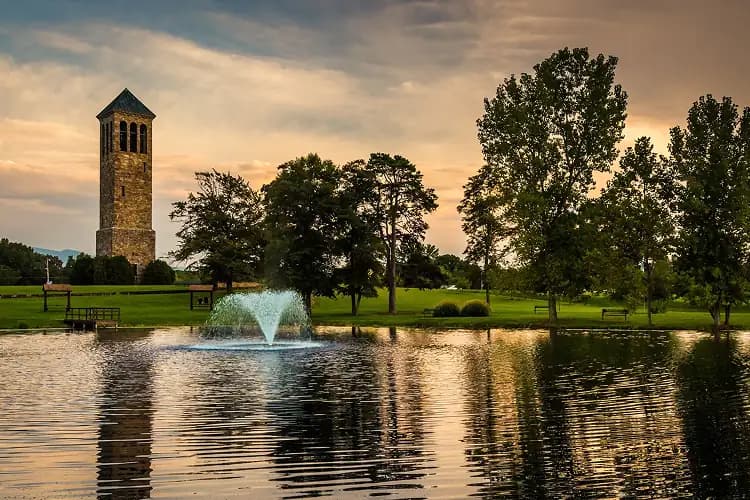 Stone bell tower and fountain pond at sunset in Springfield, Virginia, where charter bus groups stage for DC day trips