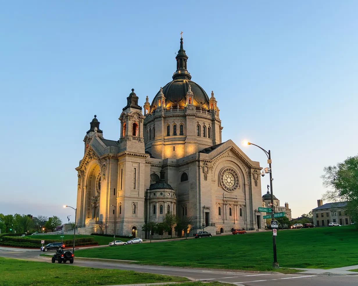 Cathedral of Saint Paul dome at golden hour above a green lawn in St. Paul, Minnesota, a landmark near downtown charter bus pickup points