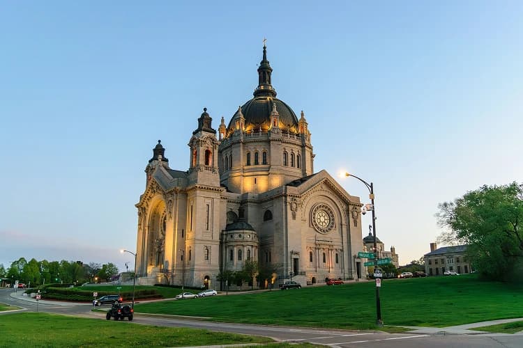 Cathedral of Saint Paul dome at golden hour above a green lawn in St. Paul, Minnesota, a landmark near downtown charter bus pickup points