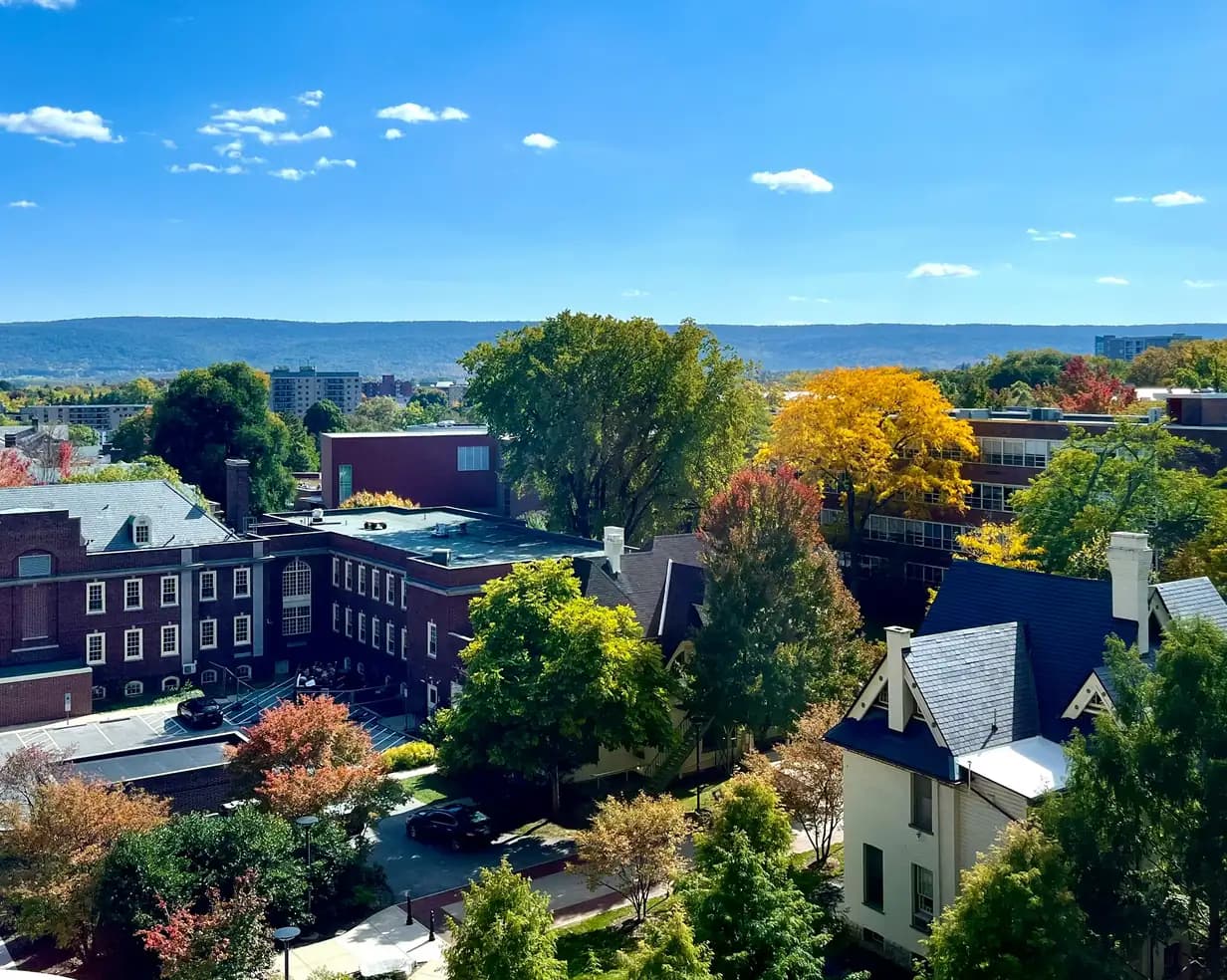Penn State University Park campus in fall color, with the Old Main tower and a ridgeline beyond, in State College, Pennsylvania