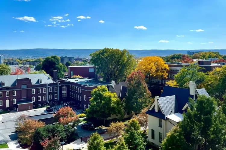 Penn State University Park campus in fall color, with the Old Main tower and a ridgeline beyond, in State College, Pennsylvania