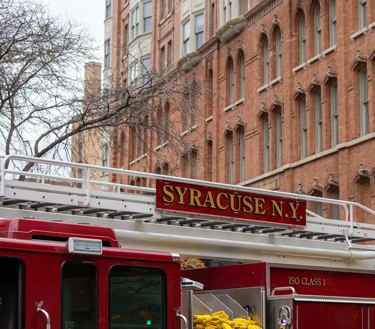 Fire truck outside a historic brick fire station in downtown Syracuse, New York, on the streets charter bus operators navigate during the I-81 rebuild