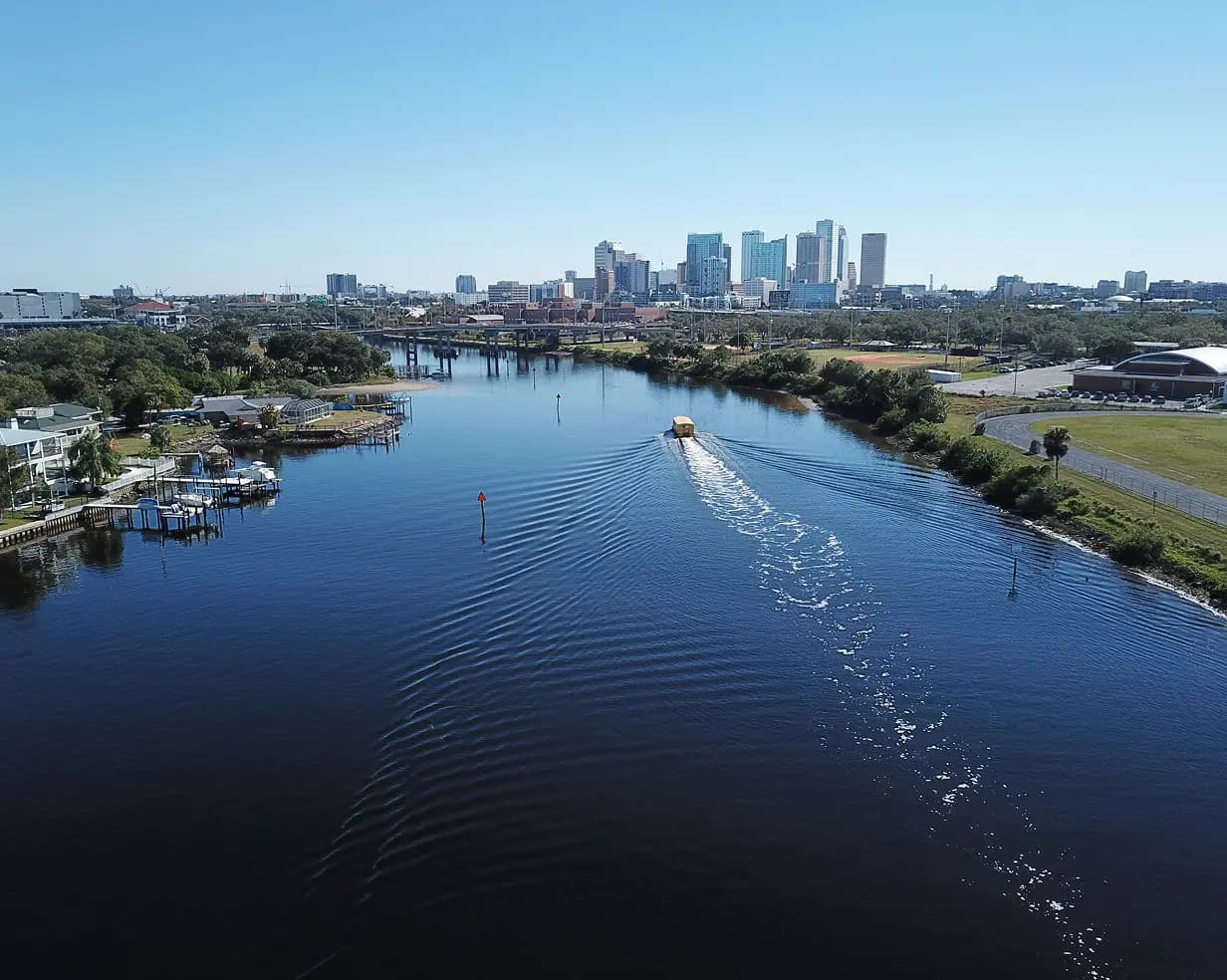 Aerial view of a boat on the waterway below the downtown Tampa, Florida skyline, a common pickup area for charter bus groups