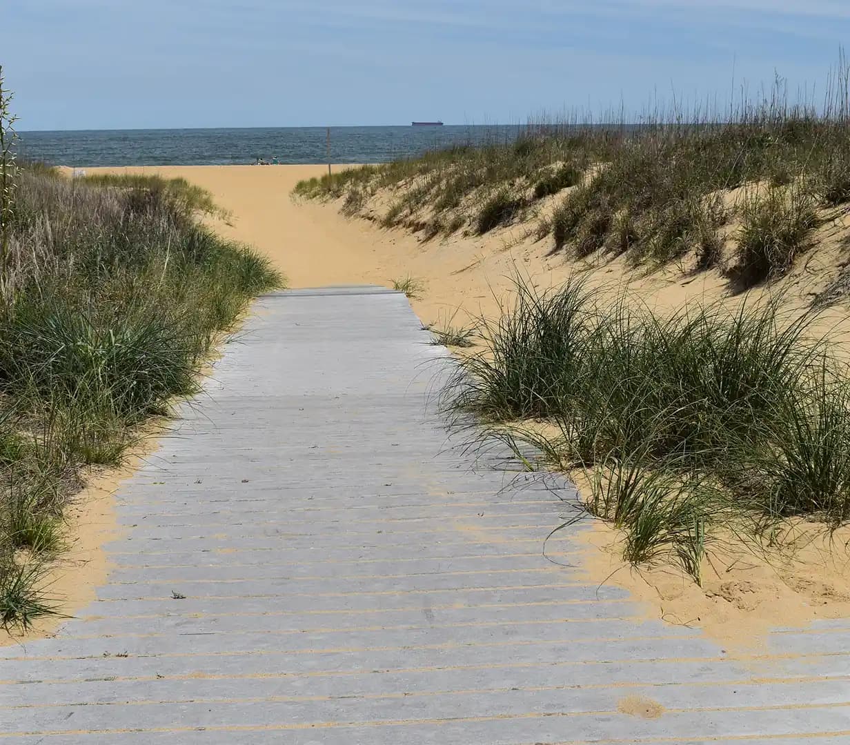 Wooden pathway crossing the sand dunes toward the ocean in Virginia Beach