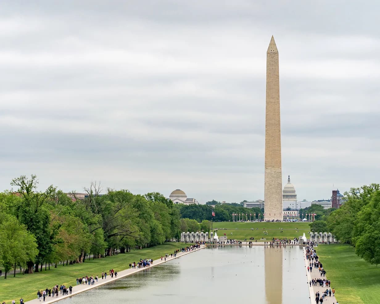 The Washington Monument reflected in the National Mall reflecting pool, a core stop on DC group itineraries