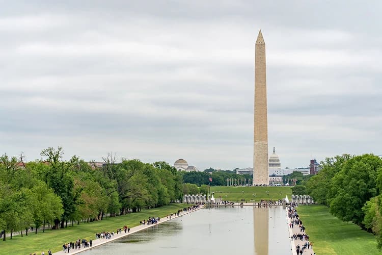 The Washington Monument reflected in the National Mall reflecting pool, a core stop on DC group itineraries