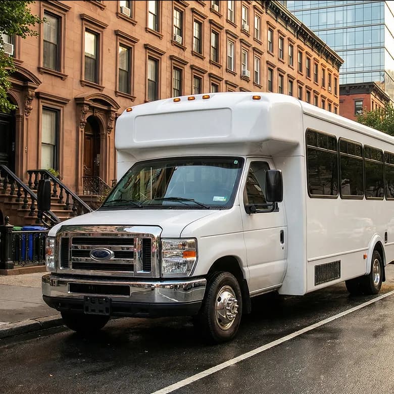 White shuttle bus on brownstone street.