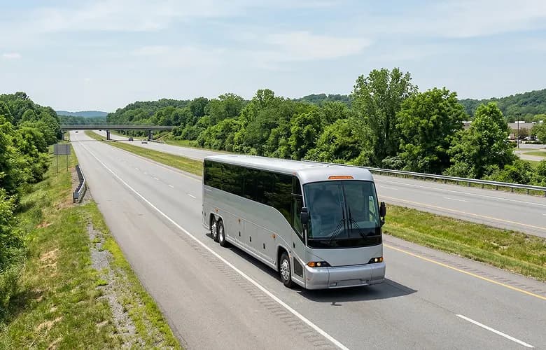 55 passenger silver charter bus rental on highway.