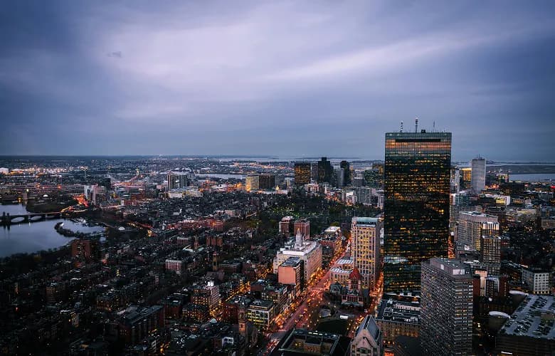 Charter bus rental Boston skyline at night.