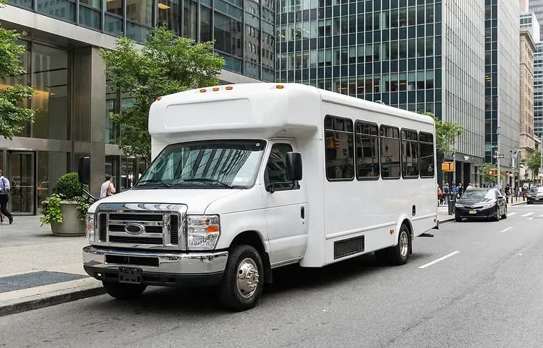 White minibus charter rental on New York city street.