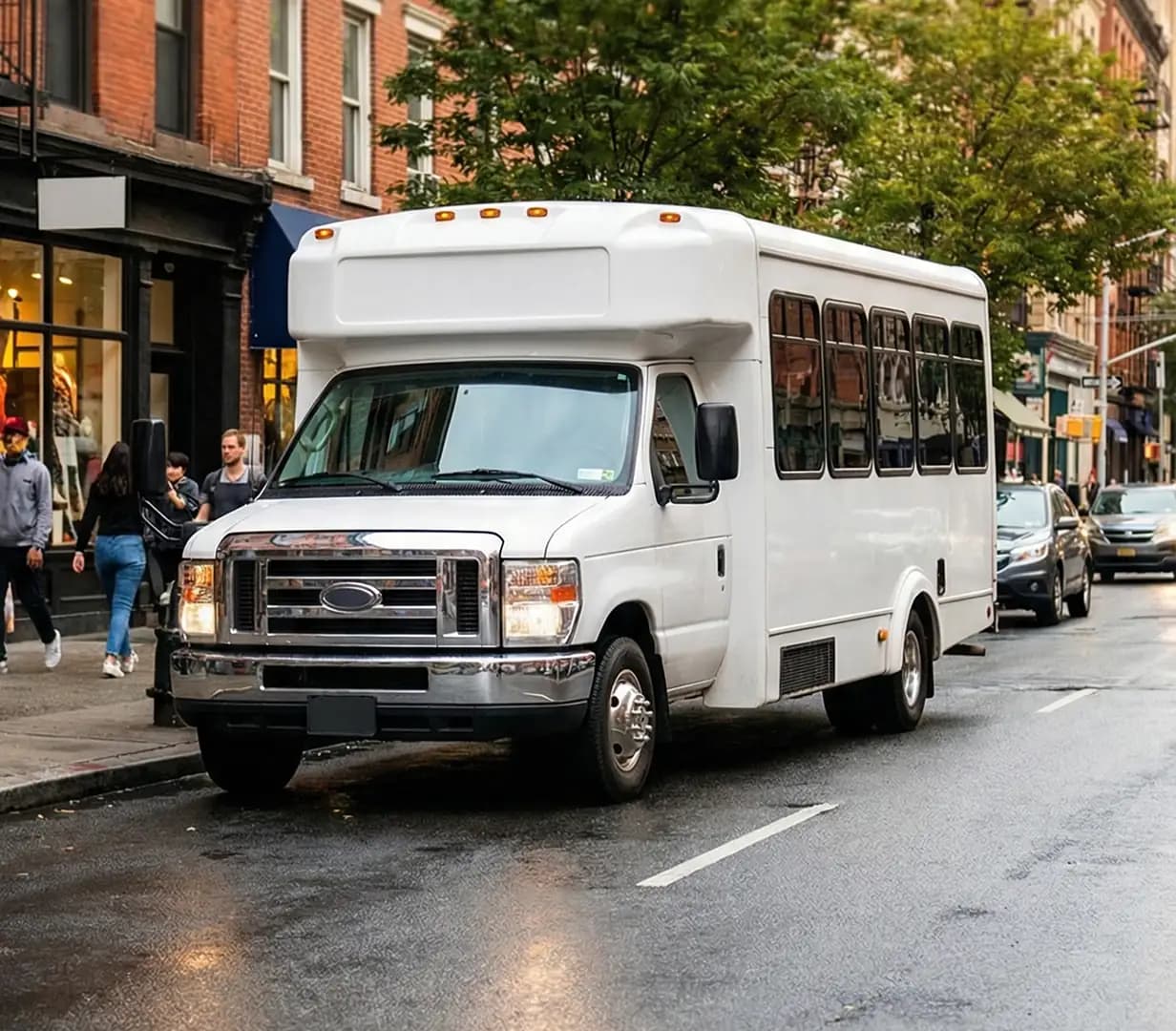 White shuttle bus on city street.