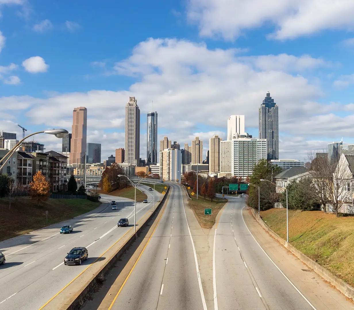 Highway traffic below the downtown Atlanta, Georgia skyscraper skyline in autumn, on the Downtown Connector charter bus operators navigate daily