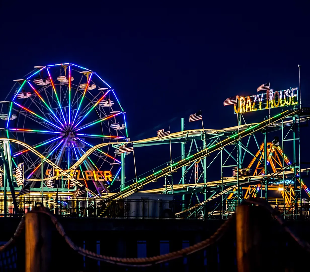 Steel Pier Ferris wheel glowing over the Atlantic City Boardwalk at night, a signature stop for charter bus groups