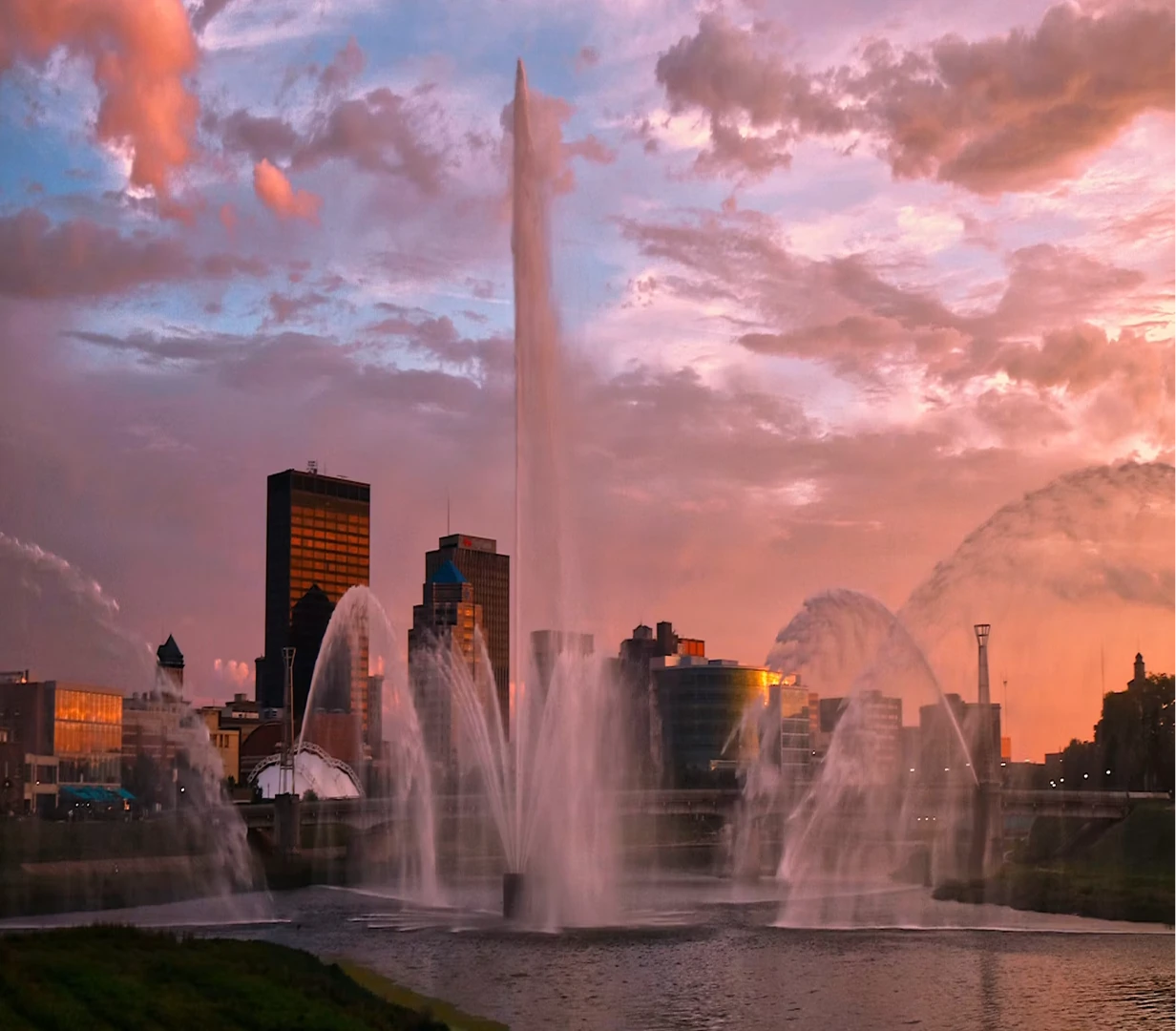 RiverScape MetroPark fountain and the downtown Dayton, Ohio skyline at dusk, a riverfront stop for charter bus groups