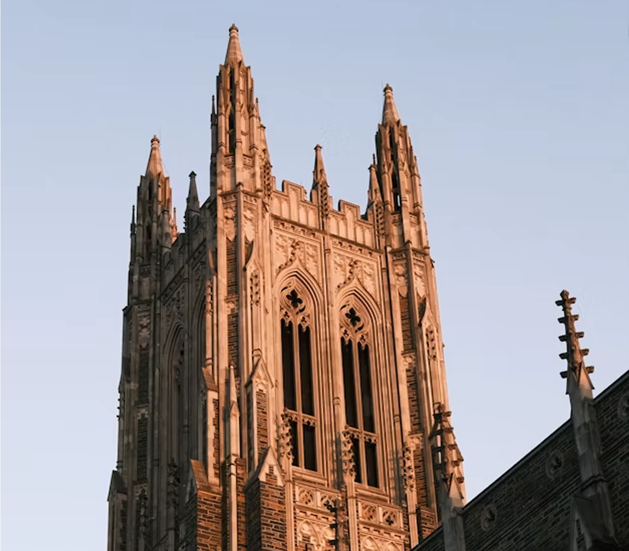 Gothic tower of Duke Chapel at golden hour in Durham, North Carolina, on the campus-visit route for charter bus groups