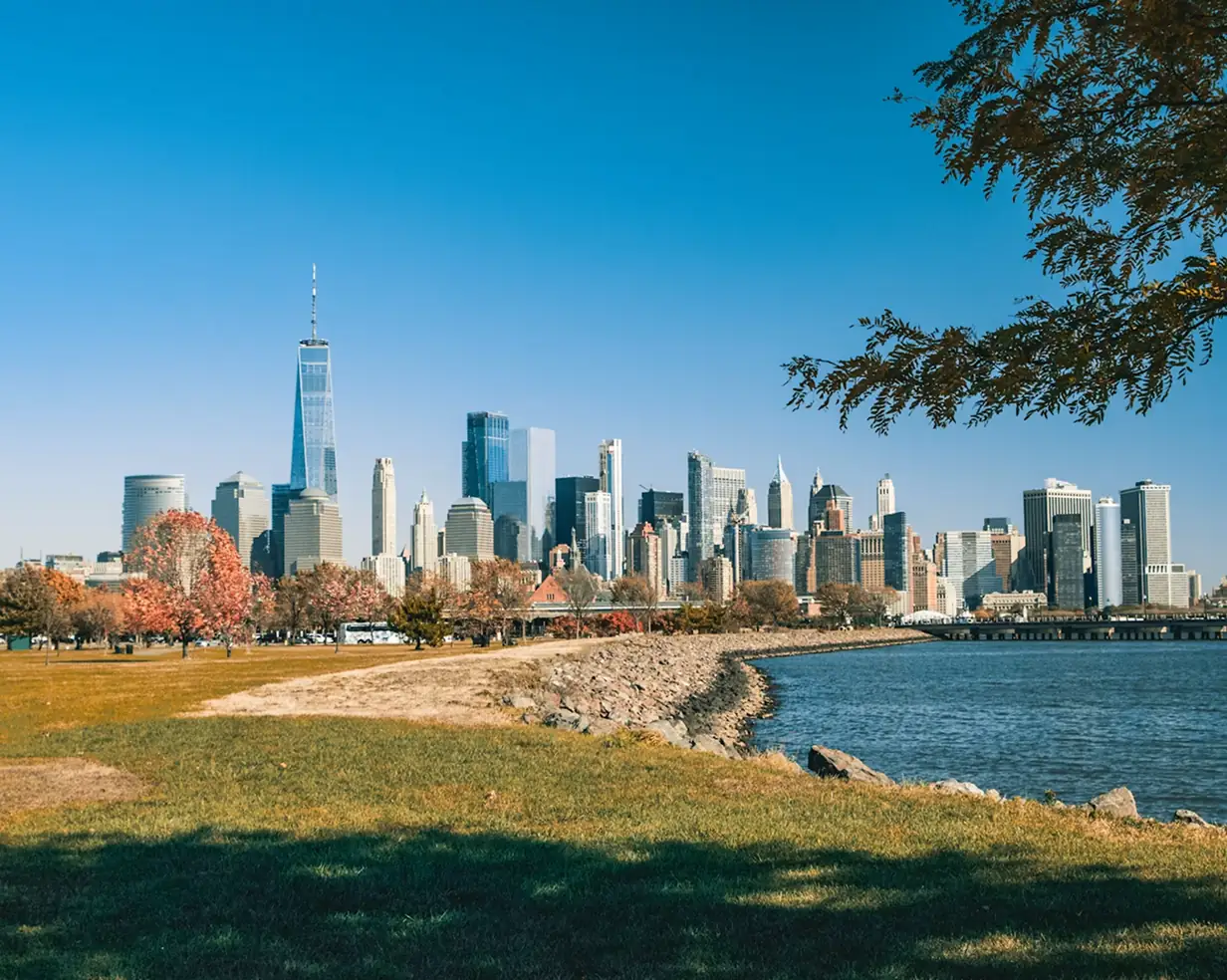 Manhattan skyline across the Hudson from Liberty State Park in Jersey City, New Jersey, in autumn, a wedding-venue and CRRNJ Terminal pickup area for charter bus groups